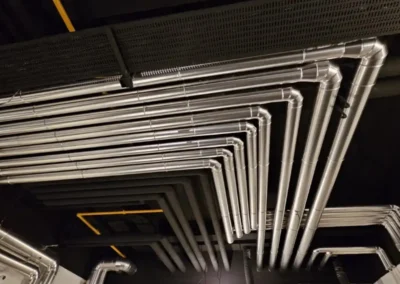 Metallummantelte Rohrleitungen in einer technisch ausgebauten Industrieanlage.