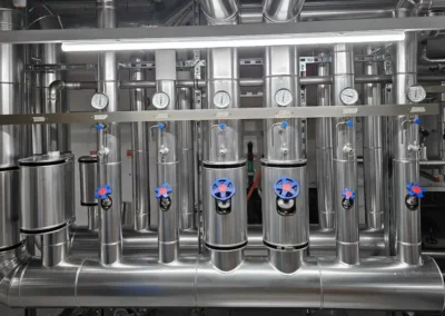 Gedämmtes Verteilsystem mit Armaturen und Druckanzeigen in einer Heizungsanlage.