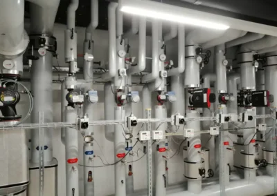 Gedämmte Heizungsleitungen und Verteilsystem in einer technischen Anlage.